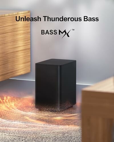 Black subwoofer in a room with wooden furniture, promoting thunderous bass.