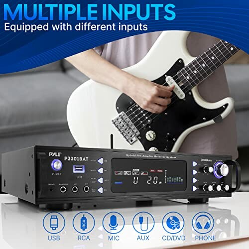 Guitarist playing electric guitar with Pyle amplifier featuring multiple inputs.