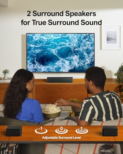 Couple watching TV with surround speakers in living room.