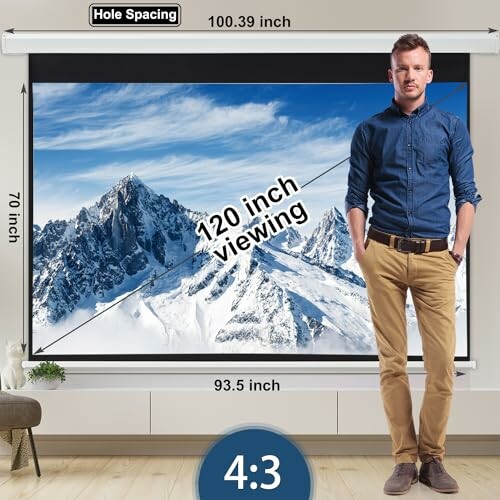 Man standing in front of a large projector screen displaying mountains, with dimensions labeled.